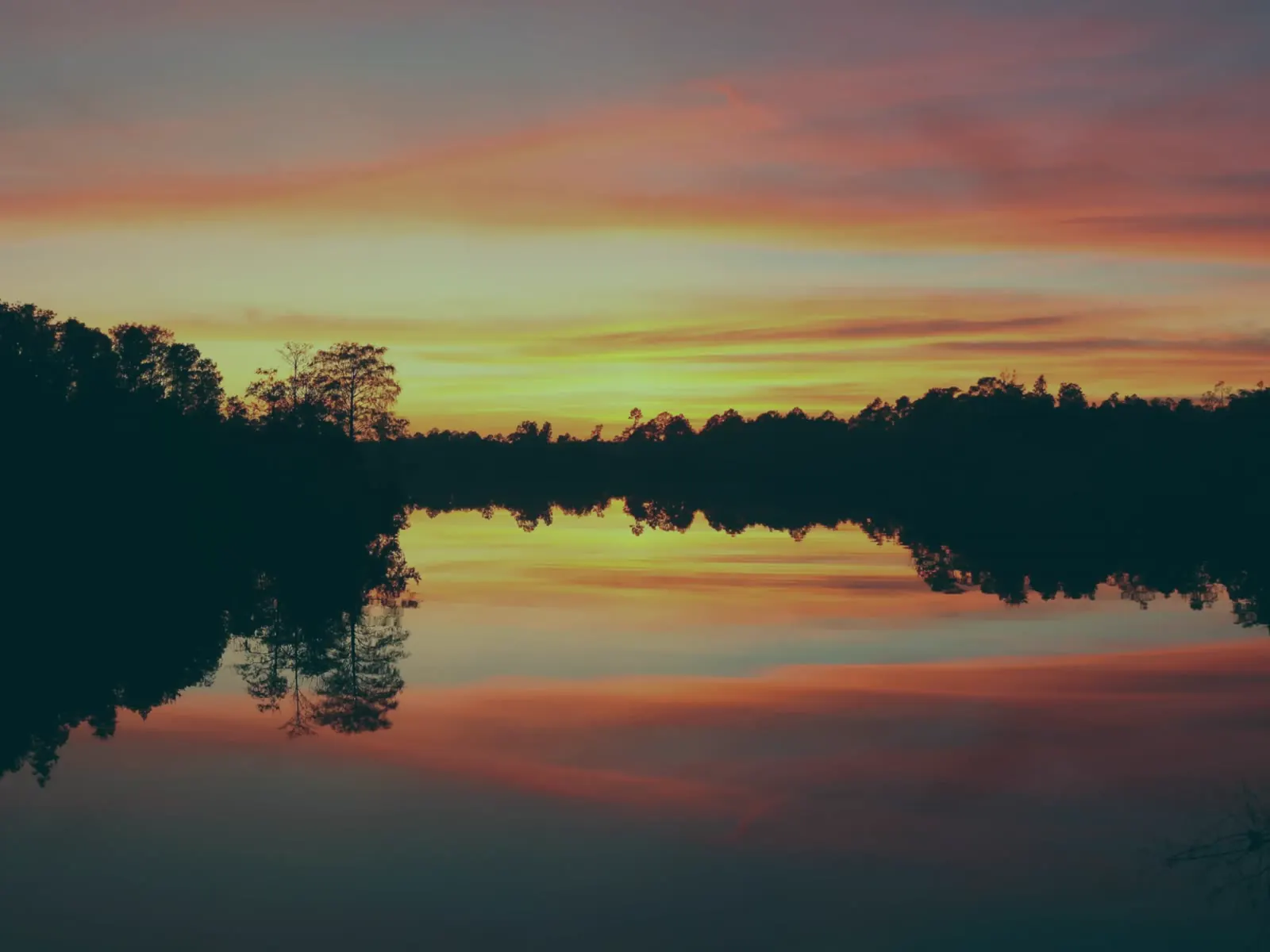 Sunset reflected on the still water of the bayou at Swamp House Marina